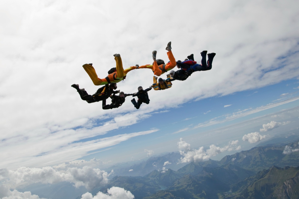 Skydivers in a formation over mountains